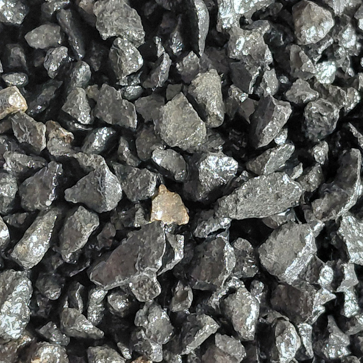 Close-up of dark gray gravel or crushed stone on a white background for terrariums