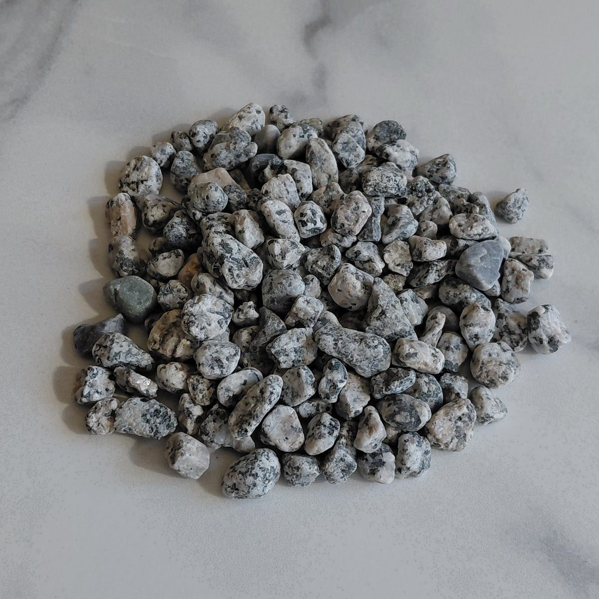 Small pile of gray stones on a marble surface